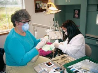 Dr. Lupita Fernandez and Lea McGuire-Pierce clean the teeth of Aneth Garcia