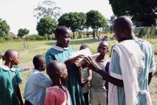 Kenyan schoolchildren flipping through pages of a new book they received thanks to Weston High School teacher Alison Douglas.