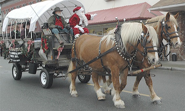 Santa traded in his sleigh and reindeer for a covered wagon with draft horses as he arrived at the Arlington festival.