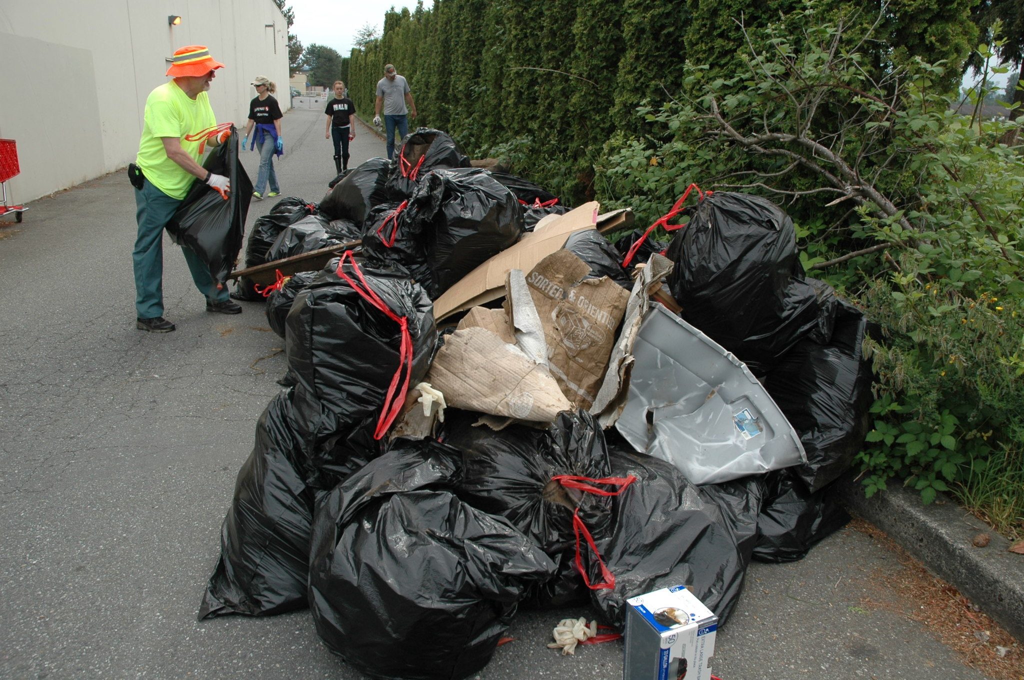 Kirk Boxleitner/Staff PhotoMichael Lloyd throws another trash bag on the pile during the May 14 cleanup at the Smokey Point Safeway.