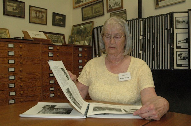 Stillaguamish Valley Pioneer Association President Myrtle Rausch peruses old photos