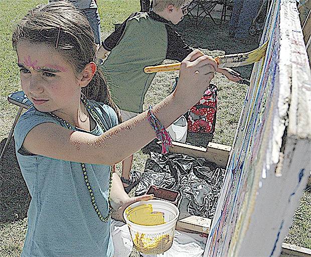 Isabella Anderson contributes to a collaborative mural painting at Art in the Park Sept. 13.