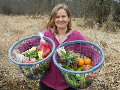 Stephanie Dickson shows off some baskets of the produce that's available at her Arlington co-op.