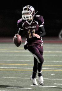 Lakewood quarterback Justin Peterson rolls out as he looks downfield to find an open receiver during the Cougars’ 33-18 loss to W.F. West on Nov. 19.