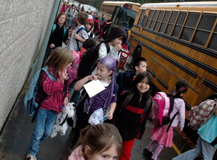 Students at Eagle Creek stream out of the school gymnasium in February. Larger classrooms in some grades may be a product of less projected state and federal revenue for the Arlington School District.