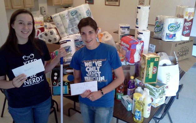 Arlington High School National Honor Society students Grayson Baden and Emily Spores show off the supplies they collected and donated to Housing Hope