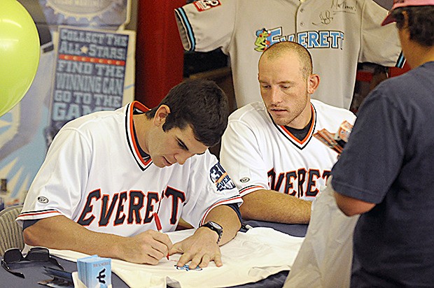 Kyle Petty and Adam Martin of the Everett Aqua Sox sign autographs for fans in the Arlington area.