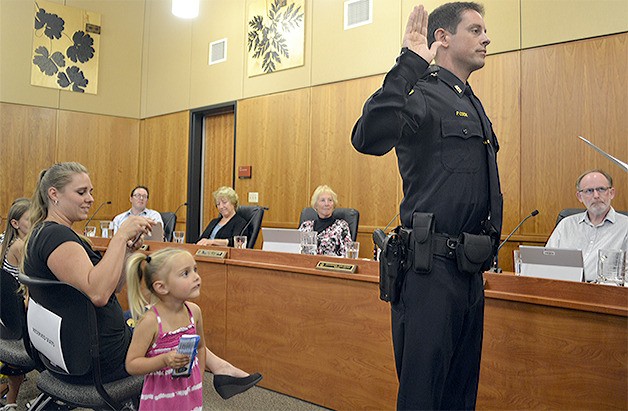 Penn Cook is sworn in as a new Arlington police officer while his family and council members watch Monday