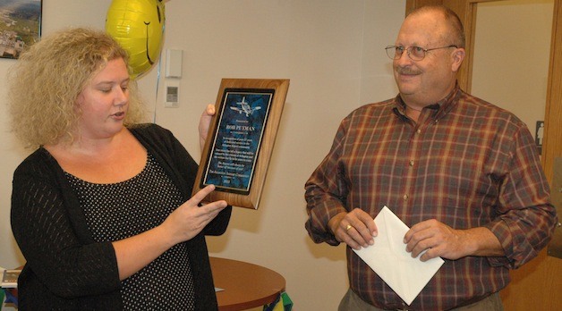 Arlington Airport Commission Chair A.J. Chase presents a plaque to retiring Airport Manager Rob Putnam on Oct. 23