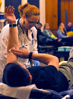 Puget Sound Blood Center nurse Erica Tomas prepares a local donor for a blood donation at the Carbajal family blood drive on Saturday