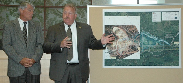 Snohomish County Executive Director Gary Haakenson looks on as county Sheriff Ty Trenary uses a map to indicate the rough vicinity of where a body was found July 22 in the Oso slide debris field.