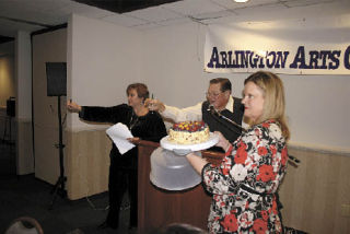 Auctioneer Fred Beal and his assistants Vicci Hilty and Vana Laura Kuhl auction off a cake from Bistro San Martin for $90 at the Fall into Art Auction Saturday