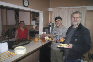 Cindy Wurst serves breakfast to Rob Mott and Mike Cobello at the Wings of Hope free breakfast at Hoseanna Christian Fellowship in Arlington