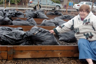 Bea Randall points out a new composting system invented by Leilani Wallace. Last fallâ€™s leaves