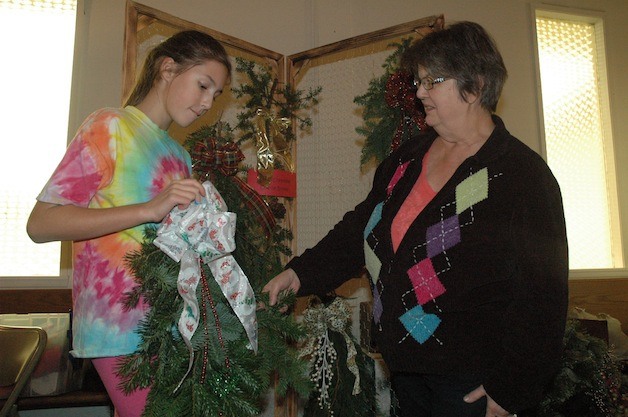 Kaiya Stauffer checks out an evergreen swag made by her grandmother