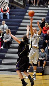 Arlington junior guard Terry Dawn shoots a three-pointer over Lake Stevens junior center Tory Rothgeb in a Wesco 4A league game on Dec. 13.