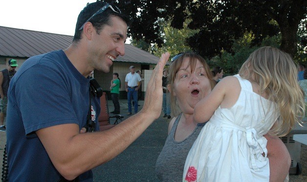 Arlington firefighter/paramedic Dan Hargroves tries to high-five Brenda Roberson's shy daughter