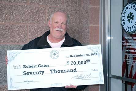 Robert Gates displays his over-sized check for $70