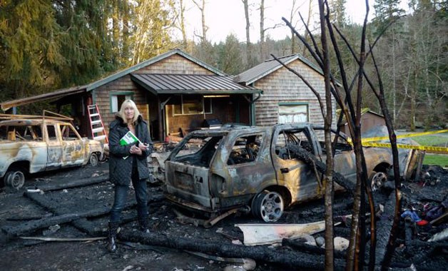 Karen Crabtree surveys the damage to her home and property near Oso after a Jan. 31 fire consumed half her house.