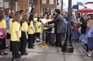 Choir on Fire sings under direction of Laurie Breon at the Holiday Open House in downtown Arlington Saturday