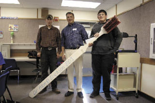 Dr. Alan Erickson thanks Micah Reinsma and Cameron Vandermeersche at Stillaguamish Valley School Oct. 21 for returning his lost toothbrush. The students found the eight-foot toothbrush in the woods while building a trail from their school to the Eagle Creek wetlands below. Erickson presented $200 and a basket of goodies to the teacher