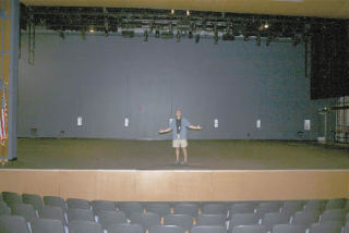 Arlington High School theater teacher Scott Moberly stands on the stage of the Brynes Performing Arts Center where he hopes his students will perform the school’s planned fall production of the musical “Peter Pan.”