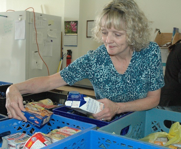 Mary Jo Schoeben filled up crates with donations from last year's Letter Carriers' Food Drive to restock the Arlington Community Food Bank's shelves.