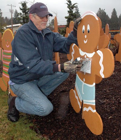 Volunteer Ken Trowbridge staples a quote from a real-life homeless child onto a gingerbread kid in Legion Park on Jan. 26.