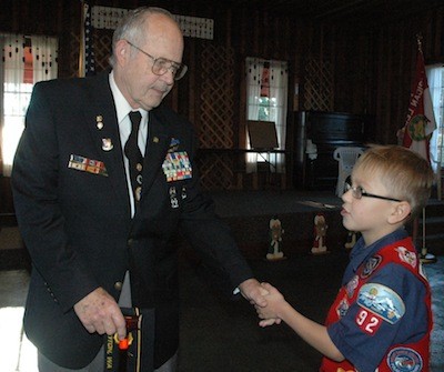 Vietnam veteran Jack Hayes receives a handshake from Boy Scout Michael Vaughn during the Stillaguamish Valley Pioneer Hall and Museum's 'Military Day' on Dec. 7.